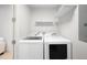 Functional laundry room with modern washer and dryer units, and convenient overhead shelving at 33 S Ogden St, Denver, CO 80209