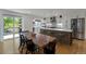 Open-concept dining area with wooden table and access to an updated kitchen with island seating at 2184 S Braun Way, Lakewood, CO 80228