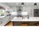 Modern kitchen featuring white cabinets, stainless steel appliances, and an island with bar seating at 2184 S Braun Way, Lakewood, CO 80228