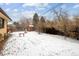 Backyard featuring snow, an outdoor shed, bench and trees at 3860 Dudley St, Wheat Ridge, CO 80033