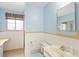 Functional bathroom with tiled walls, toilet, vanity with sink, and natural light from a window at 3860 Dudley St, Wheat Ridge, CO 80033