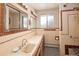 Bathroom with tiled walls, vanity with sink, and decorative mirror and lighting at 3860 Dudley St, Wheat Ridge, CO 80033