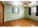 Bedroom with hardwood floors, a ceiling fan, and bright light streaming from two windows at 3860 Dudley St, Wheat Ridge, CO 80033