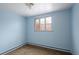 A light blue room with brown carpet and a window looking out onto a deck at 3860 Dudley St, Wheat Ridge, CO 80033