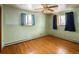 Bedroom with hardwood floors, a ceiling fan, and bright light streaming from two windows at 3860 Dudley St, Wheat Ridge, CO 80033