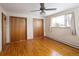 Bedroom featuring hardwood floors, two large closets and a ceiling fan at 3860 Dudley St, Wheat Ridge, CO 80033