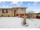 Back exterior view of the house with brick and a snow covered yard at 3860 Dudley St, Wheat Ridge, CO 80033