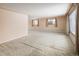 Spacious living room with carpeted floor, baseboard heaters, and natural light from large windows at 3860 Dudley St, Wheat Ridge, CO 80033