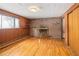 Cozy living room with hardwood floors, brick fireplace, shelving, and a window at 3860 Dudley St, Wheat Ridge, CO 80033