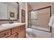 Bathroom features a vanity with a granite counter, framed mirror, and a shower-tub combo with glass doors at 9351 Viaggio Way, Highlands Ranch, CO 80126
