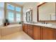 Bathroom with double vanity, tub, and large windows providing natural light at 9351 Viaggio Way, Highlands Ranch, CO 80126