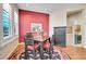 Cozy dining area with a colorful rug, striking red wall, and bright natural light at 9351 Viaggio Way, Highlands Ranch, CO 80126