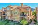 Exterior elevation of a multi-story townhome with a tiled roof, stone accents, and multiple balconies at 9351 Viaggio Way, Highlands Ranch, CO 80126