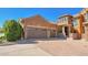 Stunning two-story stone house featuring a three-car garage and an expansive driveway at 9351 Viaggio Way, Highlands Ranch, CO 80126