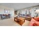 Living room with large windows and French doors, a wooden coffee table, and a dining table at 9351 Viaggio Way, Highlands Ranch, CO 80126