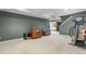 Finished basement with exercise equipment, cozy chair, TV, and ample space for recreation at 9631 S Dover Way, Littleton, CO 80127