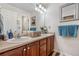 Well-lit bathroom with dual sinks, vanity, updated lighting fixtures, and ample storage space at 9631 S Dover Way, Littleton, CO 80127