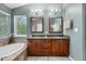 Elegant bathroom design with double vanity, soaking tub, window and stylish fixtures at 9631 S Dover Way, Littleton, CO 80127