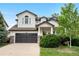 Charming two-story home with manicured lawn, mature trees, and dark grey garage door at 9631 S Dover Way, Littleton, CO 80127