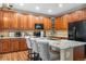 Stylish kitchen boasts wood cabinetry, stainless steel appliances, granite countertops, and three chairs at the counter at 9631 S Dover Way, Littleton, CO 80127