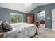 Spacious main bedroom showcasing a window for natural light, and a decorative armoire and archway to bathroom at 9631 S Dover Way, Littleton, CO 80127