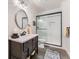 Stylish bathroom with a walk-in shower, modern vanity, and attractive round mirror at 14969 Elsinore Ave, Parker, CO 80134
