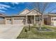 Charming home featuring a well-maintained front yard, stone accents, and an attached three-car garage at 14969 Elsinore Ave, Parker, CO 80134