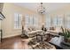 Bright living room featuring large windows, hardwood floors, neutral decor, and stylish light fixture at 14969 Elsinore Ave, Parker, CO 80134