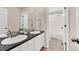 Bathroom features double sinks with black countertops and white cabinets below at 3325 Umber Cir, Castle Rock, CO 80109