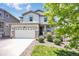 Charming two-story home featuring a manicured front lawn, complemented by a two-car garage and stone accents at 3325 Umber Cir, Castle Rock, CO 80109