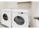 Laundry room boasts white, front-loading washer and dryer at 3325 Umber Cir, Castle Rock, CO 80109