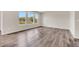 Spacious living room featuring sleek wood-look flooring, large windows, and ample natural light at 3325 Umber Cir, Castle Rock, CO 80109