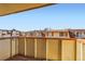Exterior balcony overlooks neighboring buildings, clear blue skies, and landscaping at 10211 Ura Ln # 304, Thornton, CO 80260