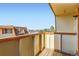 Exterior balcony overlooks community parking and landscaping under clear blue skies at 10211 Ura Ln # 304, Thornton, CO 80260