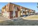 Apartment building with brown brick accents, balconies, and green space at 10211 Ura Ln # 304, Thornton, CO 80260