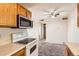 Charming kitchen with microwave above the range, wooden cabinets and view to carpeted living room at 10211 Ura Ln # 304, Thornton, CO 80260