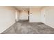 Bright living room with neutral paint and carpet, showing the flow to other rooms at 10211 Ura Ln # 304, Thornton, CO 80260