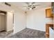 Open living space with neutral carpet, ceiling fan, and a glimpse into the kitchen at 10211 Ura Ln # 304, Thornton, CO 80260