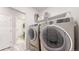 A convenient laundry room featuring a modern washer, dryer, and storage shelf at 9264 Sedalia St, Commerce City, CO 80022