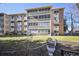 Exterior shot of condo building with decorative concrete facade, large windows and lawn at 650 S Clinton St # 11B, Denver, CO 80247