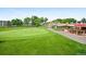 Scenic view of a lush green golf course with a clubhouse and outdoor seating at 650 S Clinton St # 11B, Denver, CO 80247