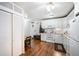Bright kitchen with white cabinets, laminate floors, dining area and appliances at 650 S Clinton St # 11B, Denver, CO 80247