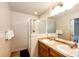Bathroom featuring double sinks, framed mirrors, and glass shower at 2091 Basil St, Strasburg, CO 80136