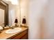 Bathroom features vanity with sink, large mirror, and neutral color palette at 2091 Basil St, Strasburg, CO 80136