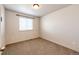 Empty bedroom with neutral carpet, a large window, and fresh paint at 2091 Basil St, Strasburg, CO 80136