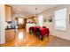 Inviting dining area next to kitchen with rich hardwood floors and bright natural light from multiple windows at 2091 Basil St, Strasburg, CO 80136