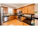 Bright kitchen features stainless appliances, light wood cabinets, and black countertops at 2091 Basil St, Strasburg, CO 80136