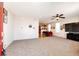 Spacious living room featuring neutral carpet, a ceiling fan, and views into the dining area and kitchen at 2091 Basil St, Strasburg, CO 80136