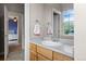 Bathroom with wood cabinets, sink, and a view to an adjacent bedroom through a doorway at 6040 Virgil St, Arvada, CO 80403