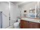 Bathroom featuring a shower stall with glass doors, neutral tile flooring, and an oak vanity with a sink at 6040 Virgil St, Arvada, CO 80403